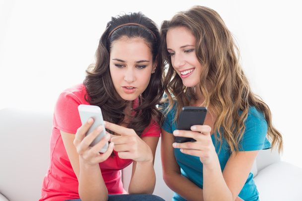 Female friends in sunglasses reading text message - Foto, Imagem