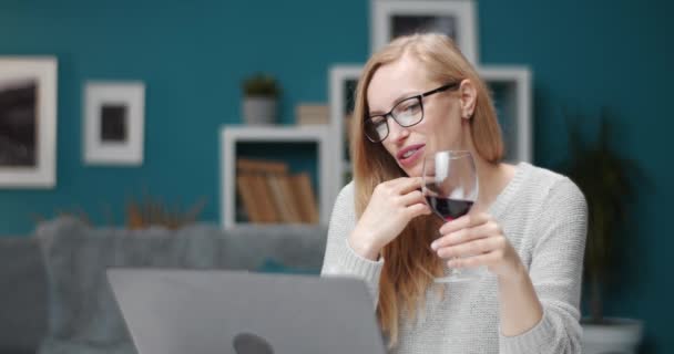 Entspannte Dame trinkt Wein während Videochat auf Laptop - Filmmaterial, Video