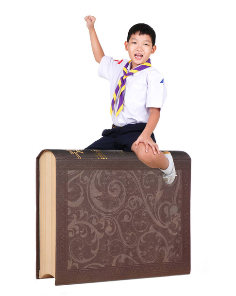Back to school. Funny little boy wear Boy scout suit sitting on Giant Book on White Background. Child from elementary school. Education. Kid with a book. Boy Scout. - Photo, Image
