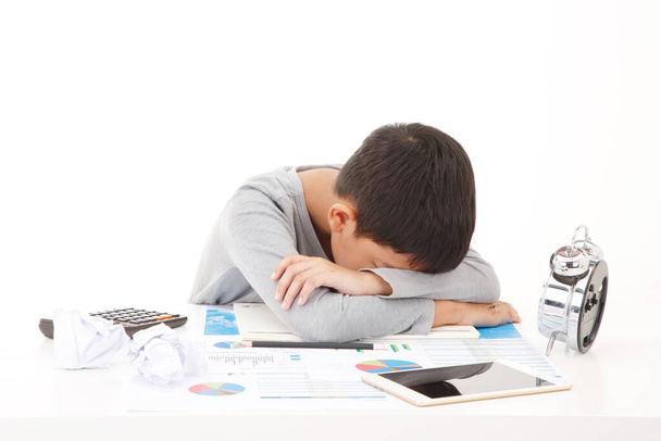Yorgun ve bitkin Asyalı ilkokul öğrencisi. Ders çalışırken uyuyakalmak. BEYAZ GÖREVLERİNE İZLENDİ. - Fotoğraf, Görsel