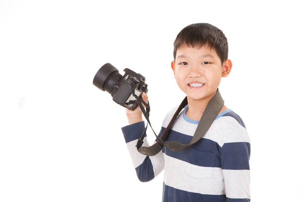Asiatischer Junge mit Kamera auf weißem Hintergrund. Zeigt Kamerapose. - Foto, Bild