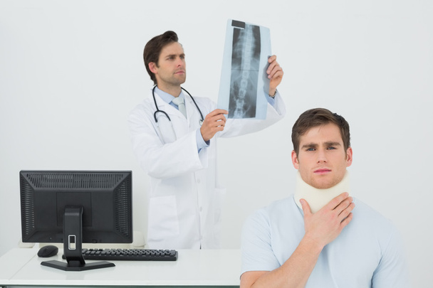 Male doctor explaining spine x-ray to patient - Foto, Imagen