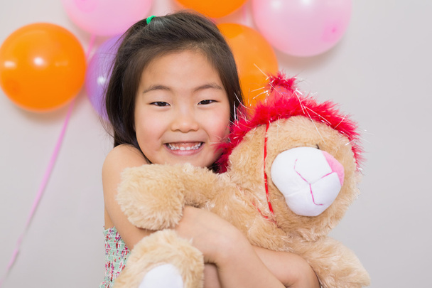 Cute girl hugging soft toy at a birthday party - Φωτογραφία, εικόνα