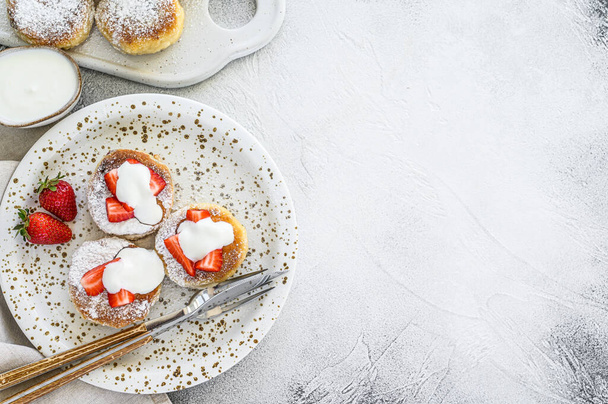 Cottage cheese pancakes, syrniki, curd fritters with strawberry. Gray background. Top view. Copy space. - Photo, Image