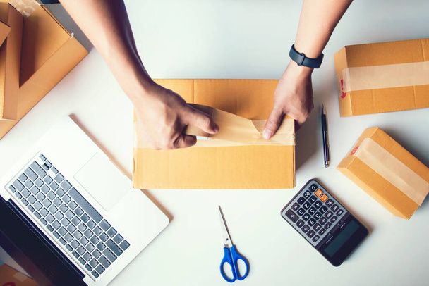 Shipment Online Sales .Man worker delivery service and working packing box, business owner working checking order to confirm before sending customer in post.Top view - 写真・画像