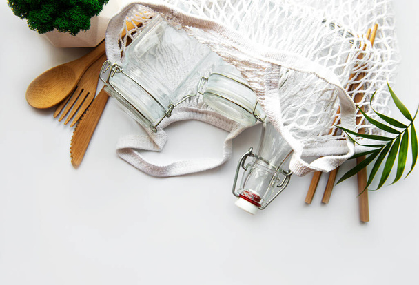 綿の袋、再利用可能なガラス瓶、竹や白い背景に木製の刃物とネットバッグ。廃棄物ゼロのコンセプト。環境に優しい。平敷 - 写真・画像