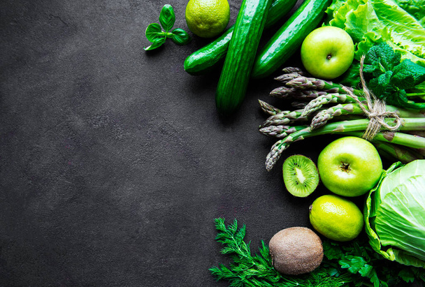 健康的なベジタリアン料理のコンセプトの背景,デトックスダイエットのための新鮮な緑の食品の選択,リンゴ,キュウリ,アスパラガス,アボカド,ライム,黒の具体的な背景にサラダトップビュー - 写真・画像