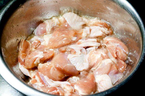 Сырое маринованное куриное мясо в миске из нержавеющей стали
  - Фото, изображение
