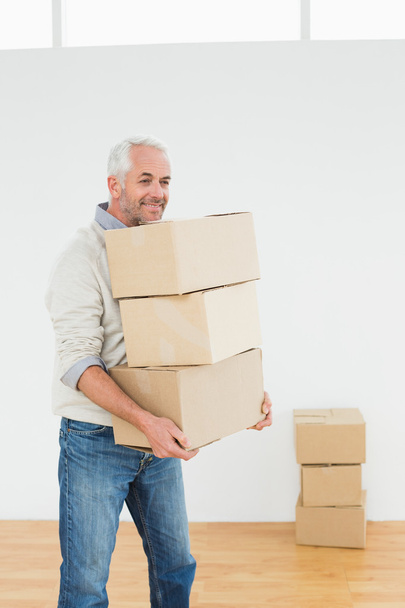 Mature man carrying boxes in a house - 写真・画像