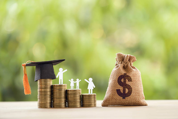 Black graduation cap, hat, student and kid, rows of rising coins, white clock on a table, natural green background. Public school funding, education funding, financial concept - Photo, Image