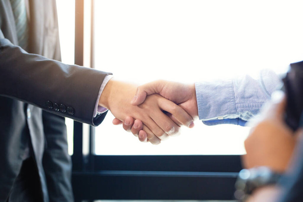 Partnership and Social connection in business join hand together,Finishing up a meeting,handshake of happy business people after contract agreement to become a partner,collaborative teamwork. - 写真・画像