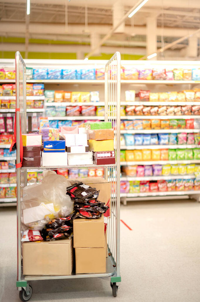 De goederen van voedsel en drank in de supermarkt plank gangpad voor te bereiden om te kopen shopper hamsteren voor gebruik in dagelijks gebruik in huis. - Foto, afbeelding