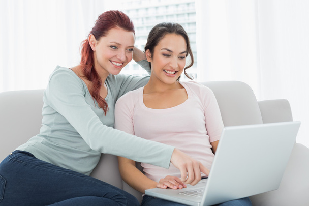 Happy relaxed female friends using laptop at home - Фото, зображення