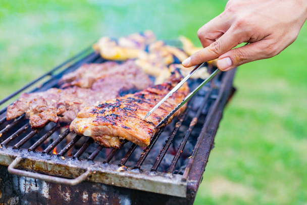 Cucinare carne barbecue al festival all'aperto nel parco. Concetto di festa estiva con famiglie e amici
. - Foto, immagini