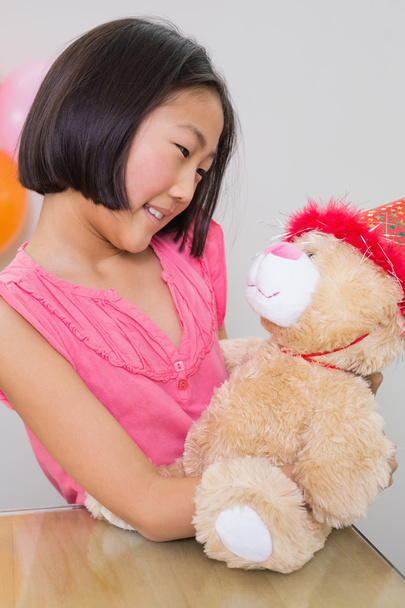Cute girl with her soft toy at a birthday party - Foto, afbeelding