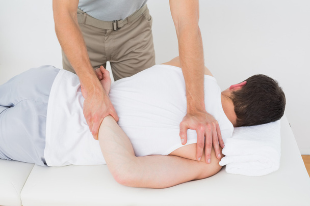 Male physiotherapist massaging patient - Foto, afbeelding