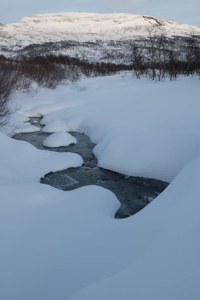 Alplerde karla çevrili donmuş suyun dikey bir resmi. - Fotoğraf, Görsel