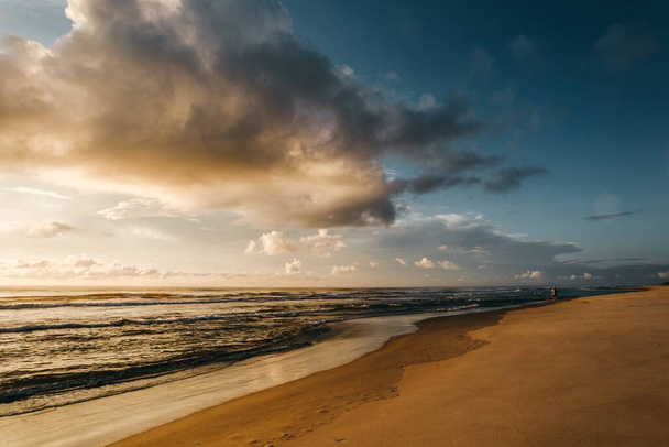 A beautiful view of a sandy beach during sunset - Fotó, kép