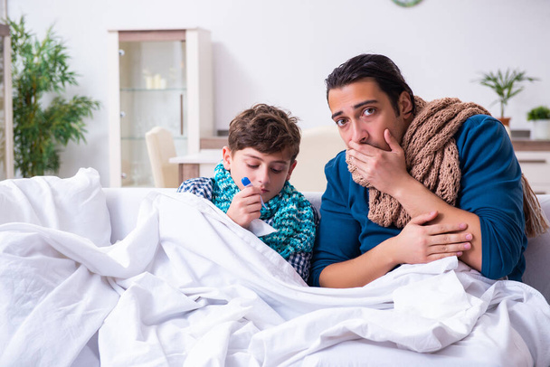 Young father caring for sick son - Foto, afbeelding