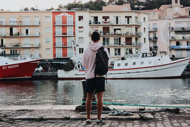 A man standing near the boats with houses - Foto, afbeelding