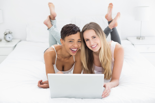 Happy relaxed female friends using laptop in bed - Foto, Imagem