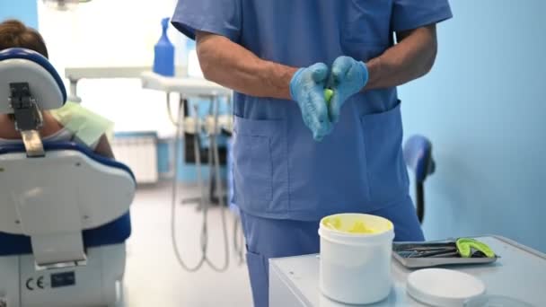 Zahnarzt in medizinischer blauer Uniform fertigt in der Zahnarztpraxis Gips oder Silikonmaterial aus einem Zahnsatz an. Stomatologie und Gesundheitskonzept.  - Filmmaterial, Video