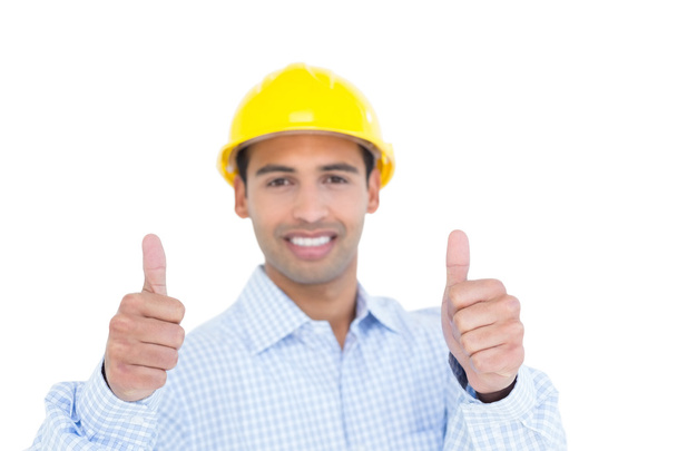 χαμογελώντας handyman σε κίτρινο σκληρό καπέλο χειρονομώ αντίχειρες - Φωτογραφία, εικόνα