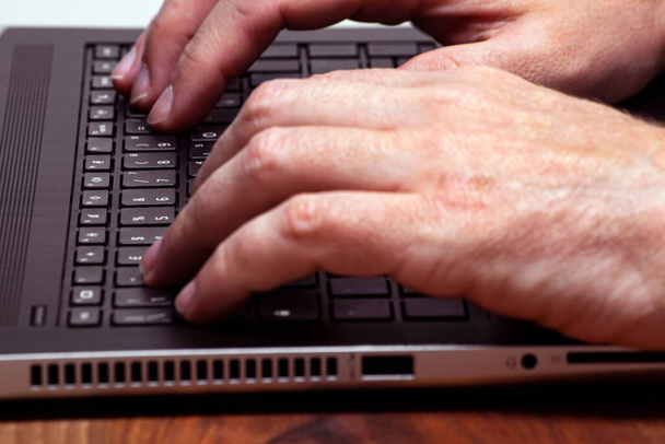 Miesten kädet kirjoittavat kannettavan tietokoneen näppäimistöön. liiketoiminta, studyng, älykäs työ käsitteet - Valokuva, kuva