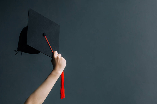 Raising hands with graduation cap on gray board.Celebration Education Graduation Student Success Learning Concept - Foto, imagen