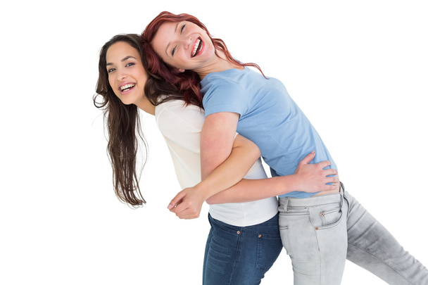 Portrait of a young woman carrying female friend on back - Foto, Imagem