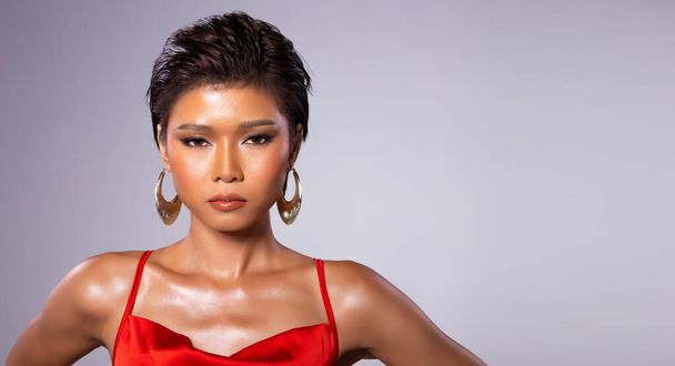 Portrait half body of Fashion Young tanned skin slim Asian Woman short hair wear red gown dress, express strong feeling poses. Studio gray Background copy space - Foto, Imagem