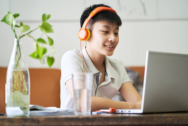 アジアの子供取るオンラインクラスで家の笑顔&着用ヘッドセット - 写真・画像