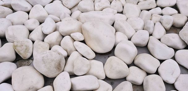 Fond ou texture de différentes pierres lisses blanches, cailloux de rivière. Décoration pour jardin ou fontaine
. - Photo, image