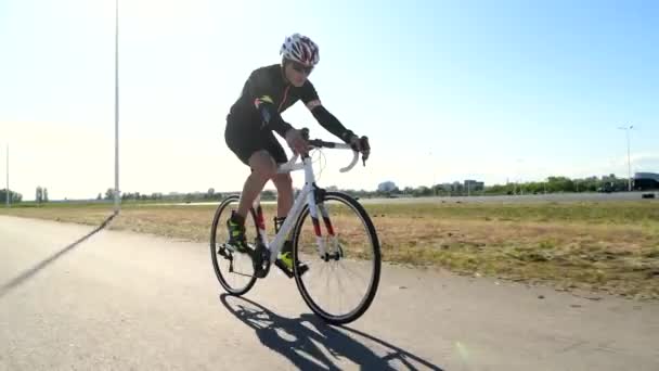 Triatleta profesional ciclismo bicicleta de carretera, pedaleando bicicleta de carretera, concepto de deporte - Imágenes, Vídeo