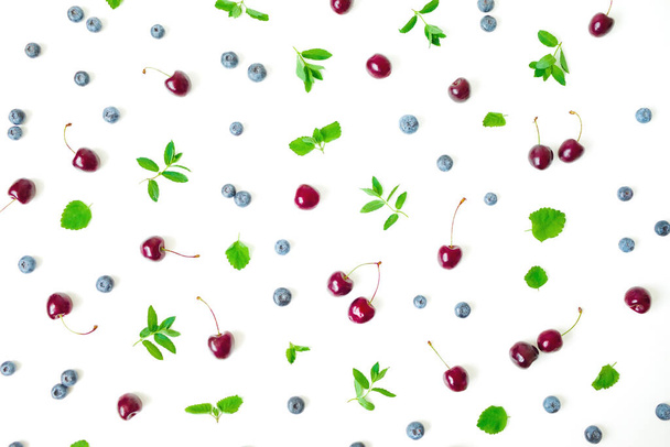 Cherry and blueberries with mint on white background. Top view. Flat lay - Foto, Imagem