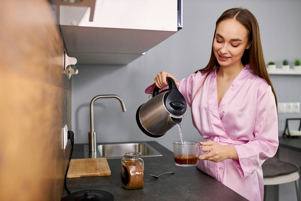 mujer haciendo una taza de café para el desayuno
 - Foto, imagen