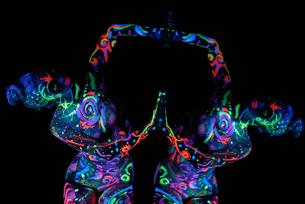 Art woman body art on the body dancing in ultraviolet light. Bright abstract drawings on the girl body neon color. Fashion and art woman - Zdjęcie, obraz