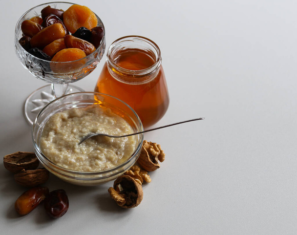 still life with oatmeal, honey and dried fruit - Foto, Imagen