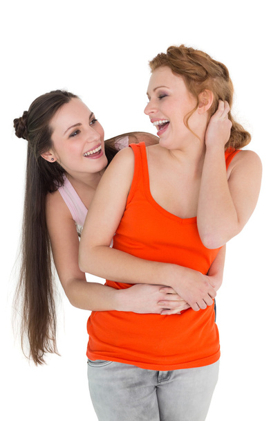 Young female embracing her cheerful friend - Фото, зображення