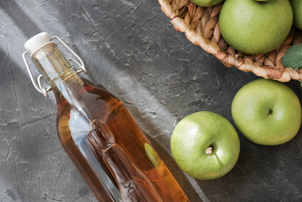 Omenaviinietikkaa. Pullo kotitekoista omenaviinietikkaa tai siideriä harmaalla pohjalla. Terveellistä luomuruokaa laihtuminen. fermentoitu ruoka fot gut ja sydämen terveys. - Valokuva, kuva