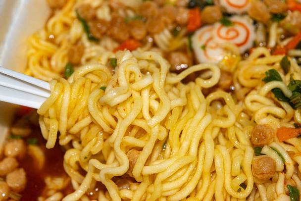 Cooked instant noodles with spices, dried vegetables and freeze-dried meat. Close up - Photo, Image