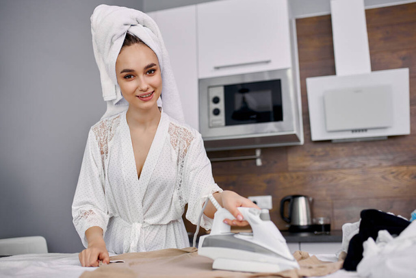 portrait ofyoung adorable housewife is carefully ironing clothes - Foto, immagini