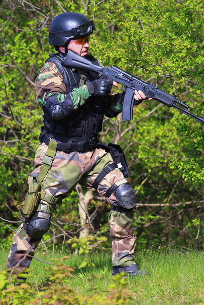 Jugador de Airsoft con un rifle en la mano asaltando el objetivo en el bosque
. - Foto, imagen