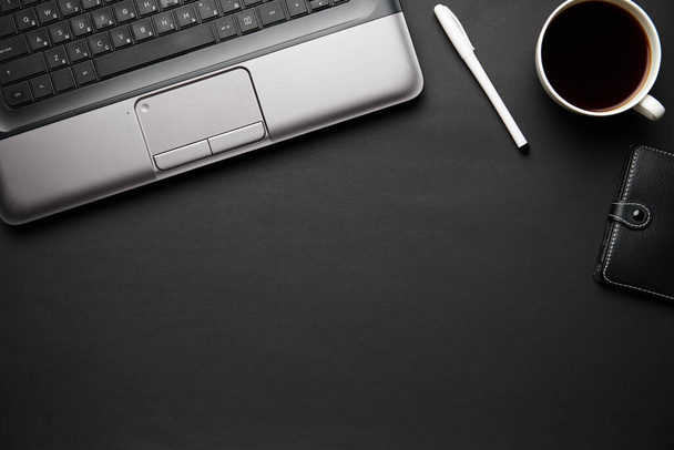 Laptop, defter, kalem ve bir sürü şeyle modern siyah ofis masasının en üst görüntüsü. Düz masa yerleşimi. Metin için alanı kopyala. - Fotoğraf, Görsel