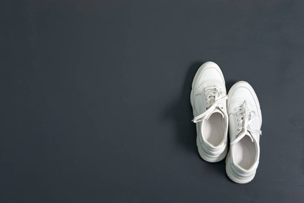 White fashionable leather sneakers for women on grey background with copy space. Thick-soled sneakers. - 写真・画像