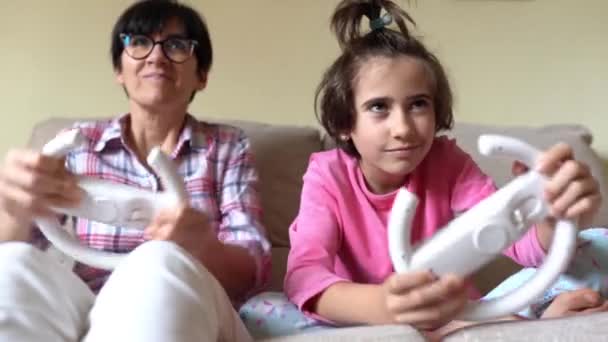 Madre e hija jugando videojuegos de coches en casa
 - Metraje, vídeo