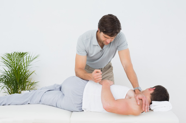 Male physiotherapist examining patient - Фото, зображення
