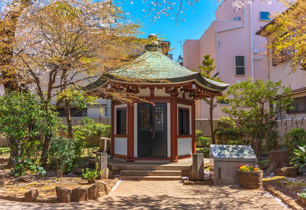 Pabellón hexagonal dedicado al fundador de la Universidad de las Artes de Tokio o Geidai en el Okakura Tenshin Memorial Park de Yanaka bajo los cerezos
. - Foto, Imagen