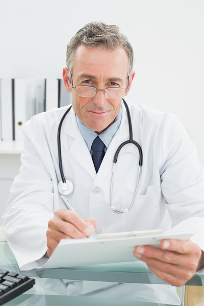 Doctor reading a report at medical office - Φωτογραφία, εικόνα
