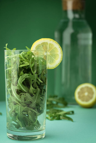 Green vegetable smoothie, cocktail of greens and lemon slice in front of trendy deep green background. Healthy food, nutrition, diet, vitamins. Organic healthcare, summer and spring concept. - Fotografie, Obrázek